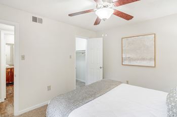 a bedroom with a large bed and a ceiling fan